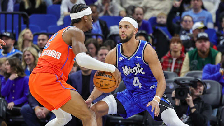 Feb 13, 2024; Orlando, Florida, USA; Orlando Magic guard Jalen Suggs (4) defends Oklahoma City Thunder guard Shai Gilgeous-Alexander (2) during the first quarter at Amway Center. Mandatory Credit: Mike Watters-Imagn Images