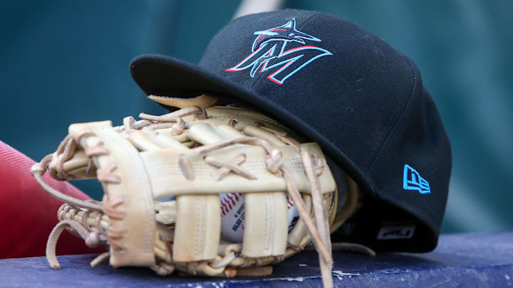 Apr 24, 2024; Atlanta, Georgia, USA; A detailed view of a Miami Marlins hat and glove in the dugout before a game against the Atlanta Braves at Truist Park. 