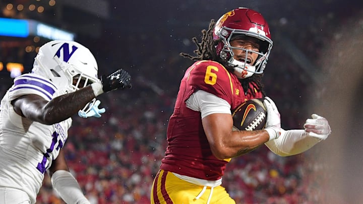 Nov 7, 2025; Los Angeles, California, USA; Southern California Trojans wide receiver Makai Lemon (6) scores a touchdown against Northwestern Wildcats defensive back Josh Fussell (13) during the first half at the Los Angeles Memorial Coliseum. Mandatory Credit: Gary A. Vasquez-Imagn Images