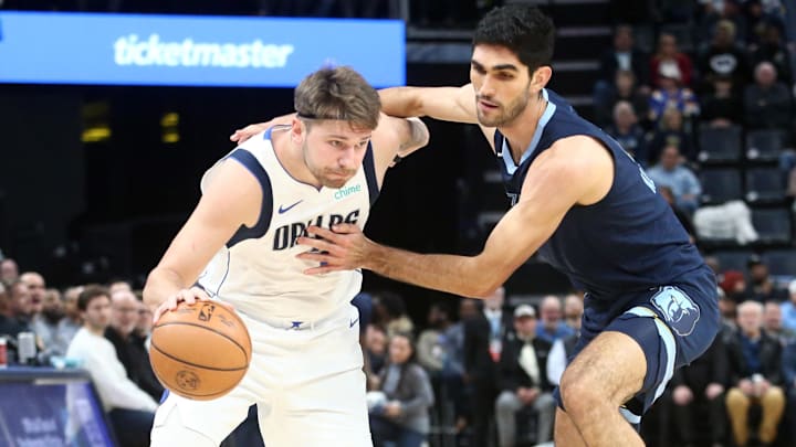 Dec 11, 2023; Memphis, Tennessee, USA; Dallas Mavericks guard Luka Doncic (77) drives to the basket as Memphis Grizzlies forward-center Santi Aldama (7) defends during the first half at FedExForum. Mandatory Credit: Petre Thomas-Imagn Images