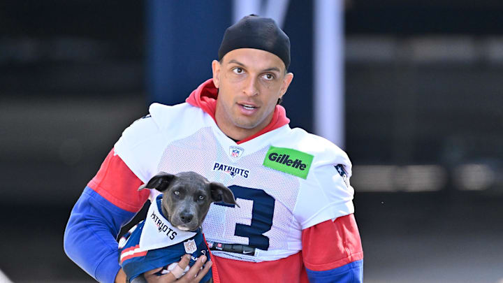 Jul 23, 2025; Foxborough, MA, USA; New England Patriots wide receiver Mack Hollins (13) delivers a puppy to a local family before addressing the media during training camp at Gillette Stadium. Mandatory Credit: Eric Canha-Imagn Images