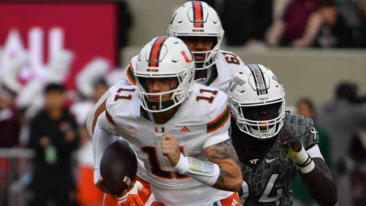 Nov 22, 2025; Blacksburg, Virginia, USA; Miami (FL) Hurricanes quarterback Carson Beck (11) runs the ball as Virginia Tech Hokies defensive lineman Elhadj Fall (94) defends at Lane Stadium. Mandatory Credit: Brian Bishop-Imagn Images