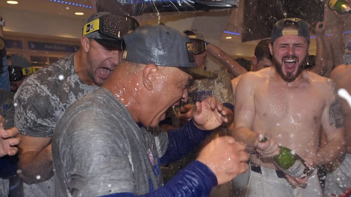 Los Angeles Dodgers second baseman Gavin Lux (right) and manager Dave Roberts (30) celebrate with champagne in the clubhouse after defeating the New York Mets in game six of the NLCS for the 2024 MLB playoffs at Dodger Stadium on Oct. 20, 2024.