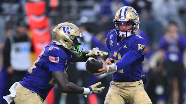 Nov 15, 2025; Seattle, Washington, USA; Washington Huskies quarterback Demond Williams Jr. (2) hands the ball off to running back Adam Mohammed (24) during the first half against the Purdue Boilermakers at Husky Stadium. Mandatory Credit: Steven Bisig-Imagn Images