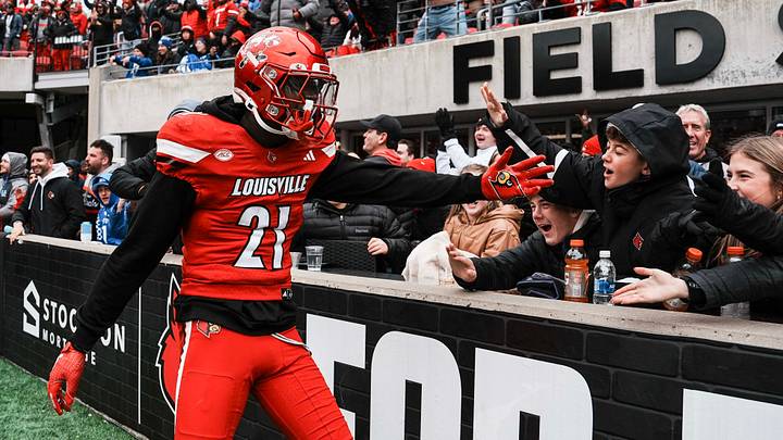 Louisville Cardinals defensive back D'Angelo Hutchinson (21) celebrates a Cardinal touchdown with fans Saturday, November 29, 2025 in Louisville, Kentucky at L&N Federal Credit Union Stadium. The Cards beat Kentucky 41-0. Louisville Cardinals defensive back D'Angelo Hutchinson (21) celebrates a Cardinal touchdown with fans Saturday, November 29, 2025 in Louisville, Kentucky at L&N Federal Credit Union Stadium. The Cards beat Kentucky 41-0.