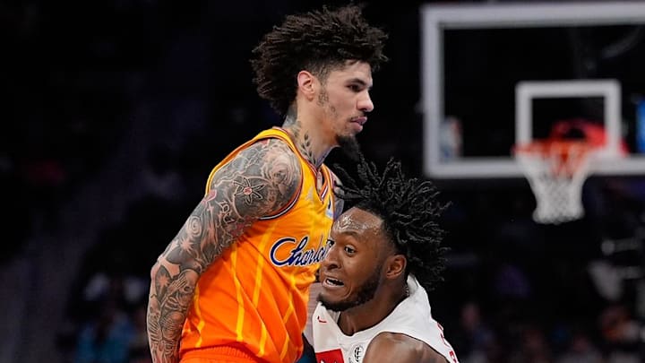 Toronto Raptors guard Immanuel Quickley drives with the ball against Charlotte Hornets guard LaMelo Ball Toronto Raptors guard Immanuel Quickley drives with the ball against Charlotte Hornets guard LaMelo Ball