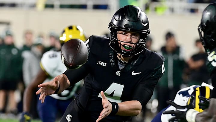 Oct 21, 2023; East Lansing, Michigan, USA; Michigan State Spartans quarterback Sam Leavitt (4) tosses the ball to Michigan State Spartans running back Nathan Carter (5) in the fourth quarter against the Michigan Wolverines at Spartan Stadium. Oct 21, 2023; East Lansing, Michigan, USA; Michigan State Spartans quarterback Sam Leavitt (4) tosses the ball to Michigan State Spartans running back Nathan Carter (5) in the fourth quarter against the Michigan Wolverines at Spartan Stadium.