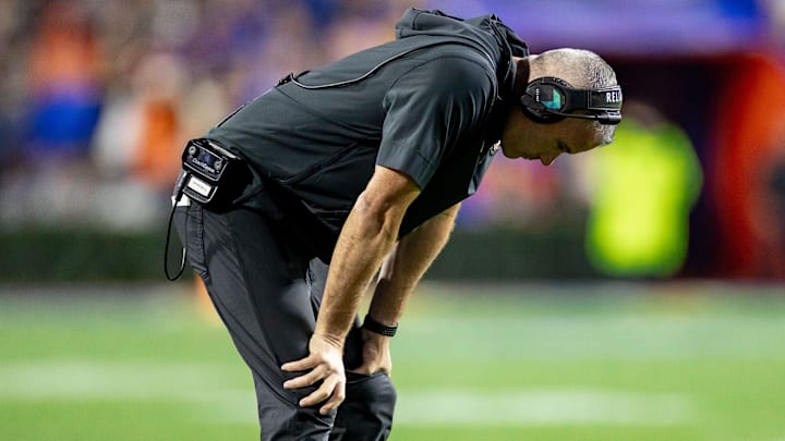 Florida State Seminoles head coach Mike Norvell holds his head between his legs during the second half against the Florida Gators at Steve Spurrier Field at Ben Hill Griffin Stadium in Gainesville, FL on Saturday, November 25, 2023. [Matt Pendleton/Gainesville Sun]