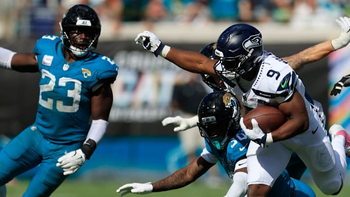 Seattle Seahawks running back Kenneth Walker III (9) rushes for yards as Jacksonville Jaguars cornerback Montaric Brown (30) pressures and linebacker Foye Oluokun (23) looks on during the fourth quarter of an NFL football matchup, Sunday, Oct. 12, 2025, at EverBank Stadium in Jacksonville, Fla. The Seahawks defeated the Jaguars 20-12. [Corey Perrine/Florida Times-Union]