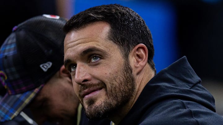 Former NFL QB Derek Carr looks on.