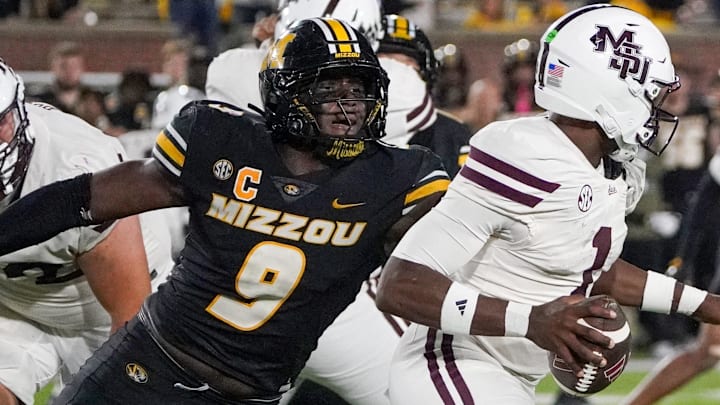 Nov 15, 2025; Columbia, Missouri, USA; Mississippi State Bulldogs quarterback Kamario Taylor (1) runs the ball as Missouri Tigers defensive end Zion Young (9) attempts the sack during the second half of the game at Faurot Field at Memorial Stadium. Mandatory Credit: Denny Medley-Imagn Images