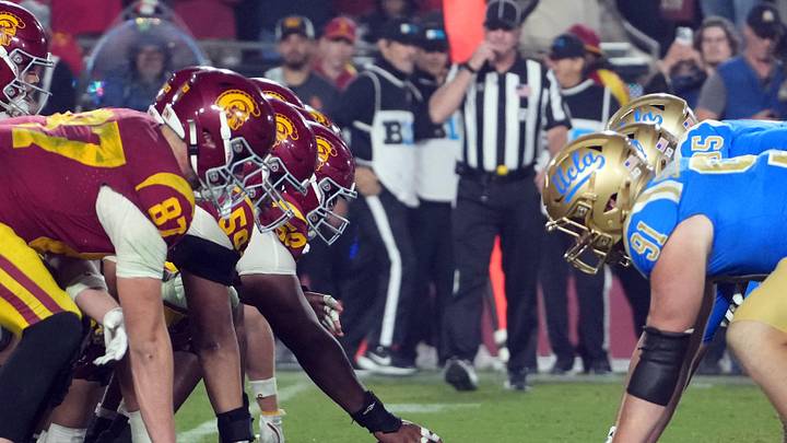 Nov 29, 2025; Los Angeles, California, USA; Helmets at the line of scrimmage as Southern California Trojans offensive lineman J'Onre Reed (50) snaps the ball against the UCLA Bruins in the second half at United Airlines Field at Los Angeles Memorial Coliseum. Mandatory Credit: Kirby Lee-Imagn Images