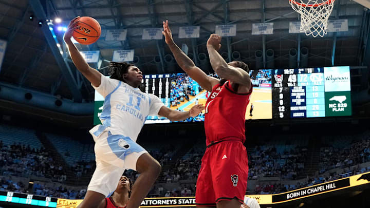 Feb 19, 2025; Chapel Hill, North Carolina, USA; North Carolina Tar Heels guard Ian Jackson (11) shoots as North Carolina State Wolfpack forward Brandon Huntley-Hatfield (1) defends in the second half at Dean E. Smith Center. Mandatory Credit: Bob Donnan-Imagn Images