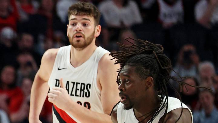 Apr 10, 2026; Portland, Oregon, USA;  LA Clippers guard Kris Dunn (8) dribbles between Portland Trail Blazers guard Scoot Henderson (00), center Donovan Clingan (23) and  guard Jrue Holiday (5) during the first half at Moda Center. Mandatory Credit: Jaime Valdez-Imagn Images