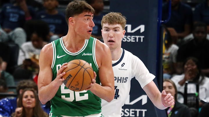 Oct 8, 2025; Memphis, Tennessee, USA; Boston Celtics center Luka Garza (52) handles the ball as Memphis Grizzlies center Lawson Lovering (34) defends during the third quarter at FedExForum.