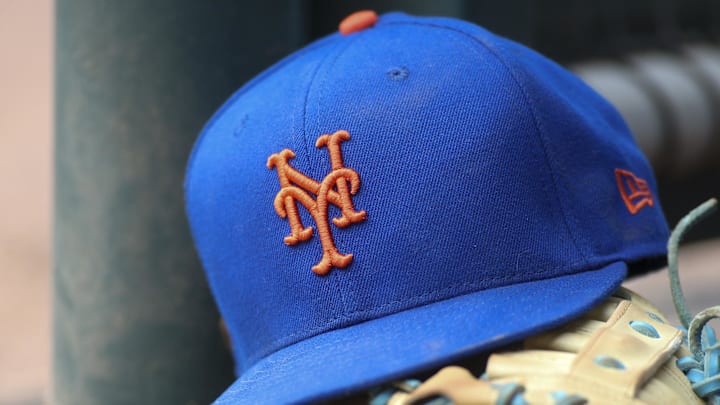 Jul 13, 2022; Atlanta, Georgia, USA; A detailed view of a New York Mets hat and glove in the dugout against the Atlanta Braves in the eighth inning at Truist Park. 