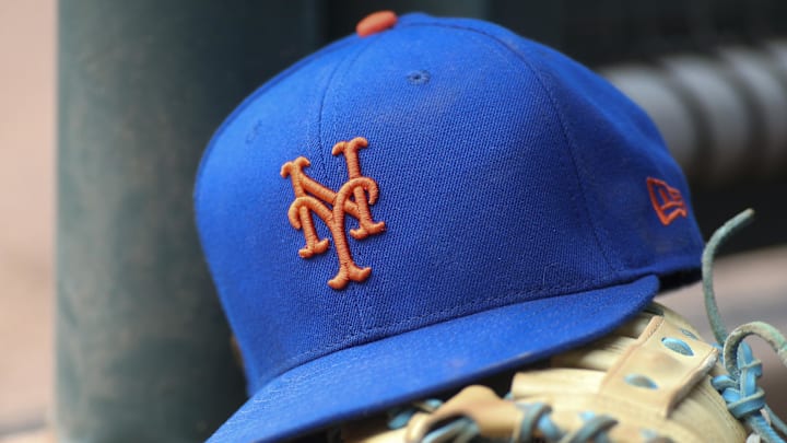 Jul 13, 2022; Atlanta, Georgia, USA; A detailed view of a New York Mets hat and glove in the dugout against the Atlanta Braves in the eighth inning at Truist Park.