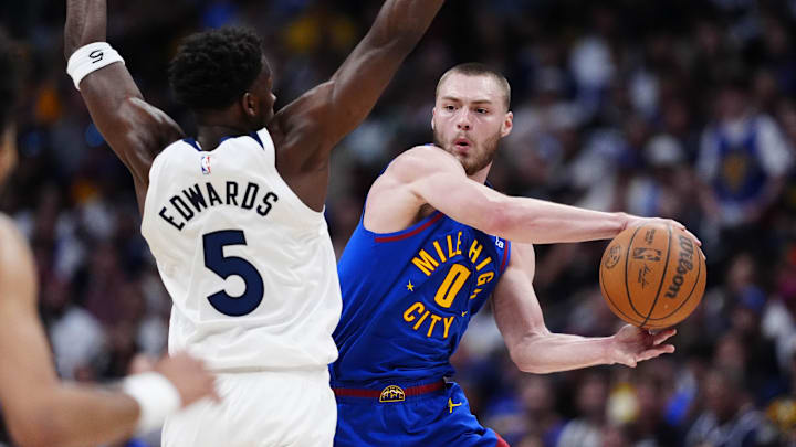 Apr 20, 2026; Denver, Colorado, USA; Denver Nuggets guard Christian Braun (0) looks to pass the ball past Minnesota Timberwolves guard Anthony Edwards (5) in the second half during game two of the first round of the 2026 NBA Playoffs at Ball Arena. Mandatory Credit: Ron Chenoy-Imagn Images