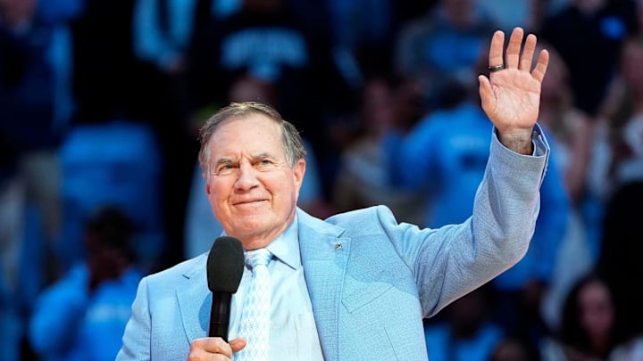 North Carolina Tar Heels head football coach Bill Belichick speaks to fans at a basketball game.