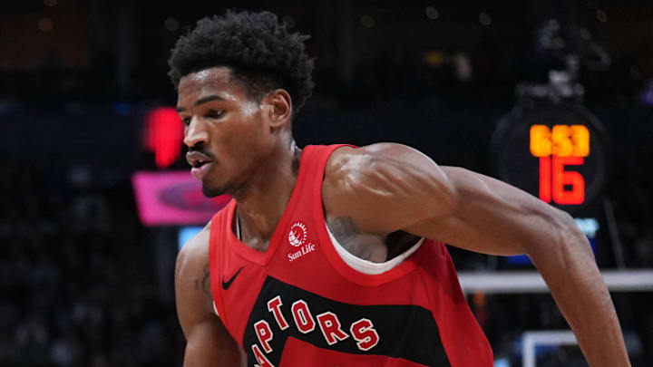Golden State Warriors guard Stephen Curry controls the ball as Toronto Raptors guard Ochai Agbaji tries to defend.