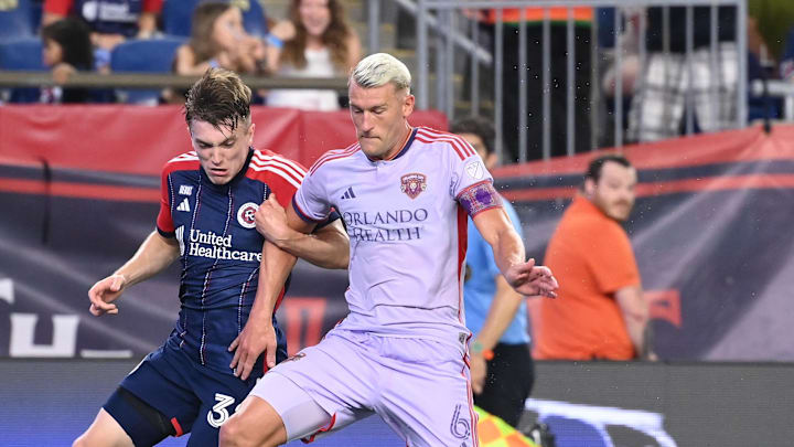 Jul 13, 2024; Foxborough, Massachusetts, USA; Orlando City SC defender Robin Jansson (6) defends against New England Revolution forward Malcolm Fry (32) during the second half at Gillette Stadium. Mandatory Credit: Eric Canha-USA TODAY Sports