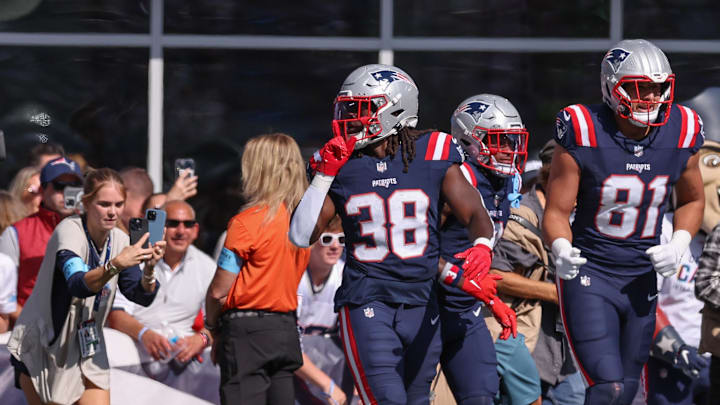 Oct 6, 2024; Foxborough, Massachusetts, USA; New England Patriots running back Rhamondre Stevenson (38) celebrates after scoring a touchdown during the first half against the Miami Dolphins at Gillette Stadium. Mandatory Credit: Paul Rutherford-Imagn Images