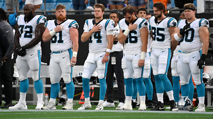 Carolina Panthers offensive tackle Taylor Moton (72) and center Matt Paradis (61) and quarterback Sam Darnold (14) and tight end Colin Thompson (86) and tight end Dan Arnold (85) and center Pat Elflein (60) during the national anthem at Bank of America Stadium.