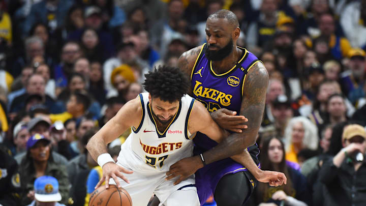 Feb 22, 2025; Denver, Colorado, USA; Denver Nuggets guard Jamal Murray (27) handles the ball as he is defended by Los Angeles Lakers forward LeBron James (23) during the second half at Ball Arena.