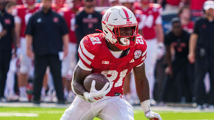 Sep 20, 2025; Lincoln, Nebraska, USA; Nebraska Cornhuskers running back Emmett Johnson (21) runs against the Michigan Wolverines during the second quarter at Memorial Stadium. Mandatory Credit: Dylan Widger-Imagn Images