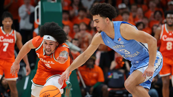 Feb 10, 2026; Coral Gables, Florida, USA; Miami Hurricanes guard Tre Donaldson (3) and North Carolina Tar Heels guard Derek Dixon (3) reach for a loose ball during the first half at Watsco Center. Mandatory Credit: Sam Navarro-Imagn Images