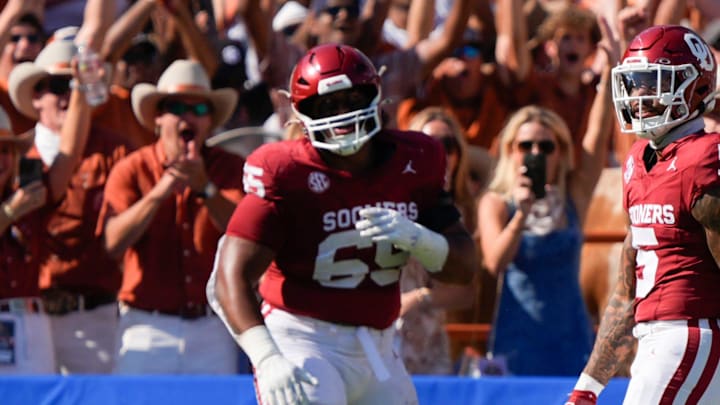 Texas fans celebrate behind Oklahoma Sooners defensive lineman Jayden Jackson (65) and defensive back Woodi Washington (5) after a Texas touchdown during the Red River Rivalry college football game between the University of Oklahoma Sooners (OU) and the Texas Longhorns at the Cotton Bowl in Dallas, Saturday, Oct. 12, 2024. Texas one 34-3.