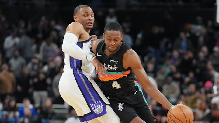 Feb 21, 2026; Austin, Texas, USA;  San Antonio Spurs guard De'Aaron Fox (4) dribbles against Sacramento Kings guard Russell Westbrook (18) in the first half at Moody Center.