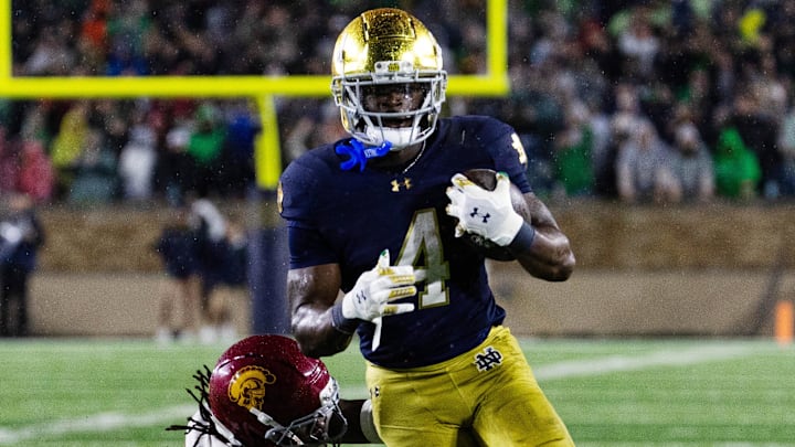 Oct 18, 2025; South Bend, Indiana, USA; Notre Dame Fighting Irish running back Jeremiyah Love (4) runs the ball while Southern California Trojans safety Bishop Fitzgerald (19)  defends in the second half at Notre Dame Stadium. 