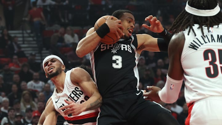 Apr 24, 2026; Portland, Oregon, USA; San Antonio Spurs forward Keldon Johnson (3) grabs a rebound over Portland Trail Blazers forward Toumani Camara (33) during the first half of Game 3 of the first round of the 2026 NBA Playoffs at Moda Center.