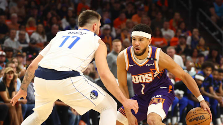 Oct 26, 2024; Phoenix, Arizona, USA; Phoenix Suns guard Devin Booker (1) against Dallas Mavericks guard Luka Doncic (77) in the first half of the home opener at Footprint Center. Mandatory Credit: Mark J. Rebilas-Imagn Images