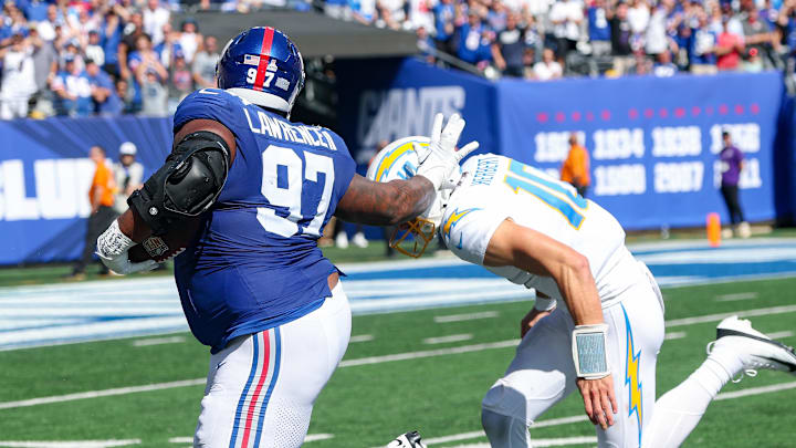 Sep 28, 2025; East Rutherford, New Jersey, USA; New York Giants defensive tackle Dexter Lawrence (97) is tackled by Los Angeles Chargers quarterback Justin Herbert (10) after intercepting a pass during the first half at MetLife Stadium. Mandatory Credit: Vincent Carchietta-Imagn Images Sep 28, 2025; East Rutherford, New Jersey, USA; New York Giants defensive tackle Dexter Lawrence (97) is tackled by Los Angeles Chargers quarterback Justin Herbert (10) after intercepting a pass during the first half at MetLife Stadium. Mandatory Credit: Vincent Carchietta-Imagn Images