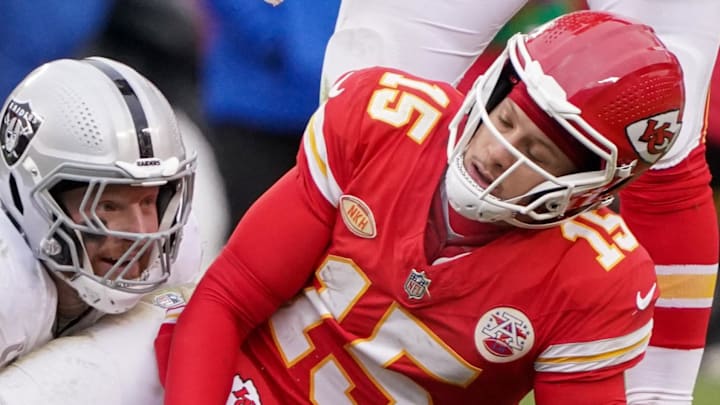 Dec 25, 2023; Kansas City, Missouri, USA; Kansas City Chiefs quarterback Patrick Mahomes (15) reacts after being sacked by Las Vegas Raiders defensive end Maxx Crosby (98) during the game at GEHA Field at Arrowhead Stadium. Mandatory Credit: Denny Medley-Imagn Images