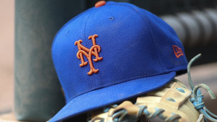 Jul 13, 2022; Atlanta, Georgia, USA; A detailed view of a New York Mets hat and glove in the dugout against the Atlanta Braves in the eighth inning at Truist Park. 
