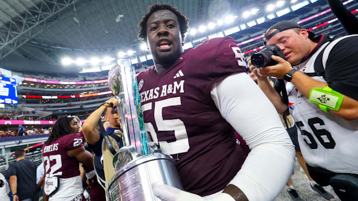 Texas A&M Aggies offensive lineman Ar'maj Reed-Adams (55) celebrates with the Southwest Classic trophy after the game against the Arkansas Razorbacks at AT&T Stadium.