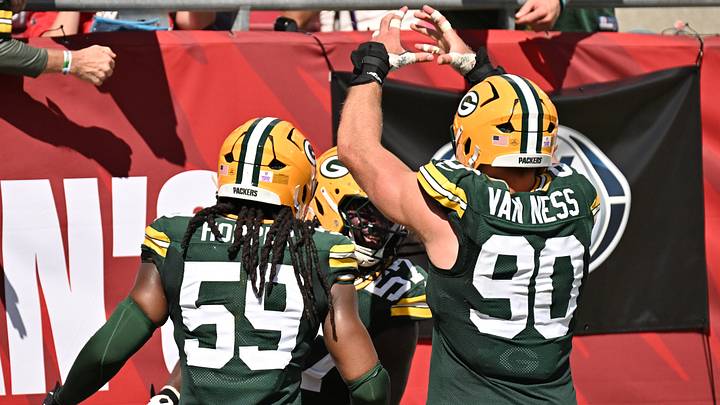 Ty'Ron Hopper (59) and Lukas Van Ness (90) celebrate after defensive end Brenton Cox Jr. almost had a safety at Tampa Bay.