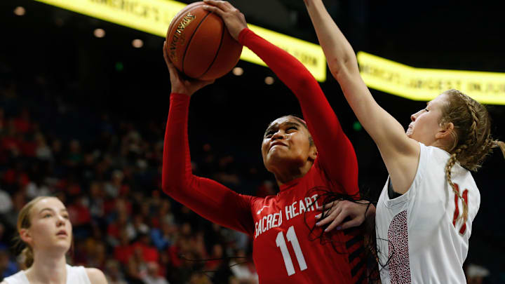 Sacred Heart's Zakiyah Johnson makes the basket against McCracken's Jayden Skaggs in the Mingua Beef Jerky Sweet 16 Girl   s Basketball Championship.