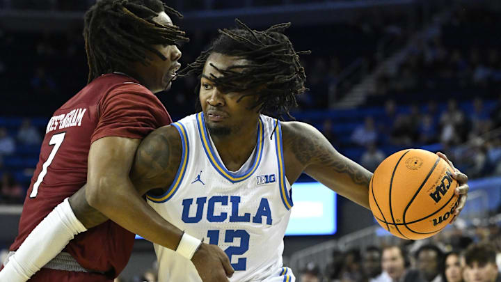 Nov 4, 2024; Los Angeles, California, USA; UCLA Bruins guard Sebastian Mack (12) drives to the basket defended by Rider Broncs forward Ife West-Ingram (7) during the first half at Pauley Pavilion presented by Wescom. Mandatory Credit: Robert Hanashiro-Imagn Images