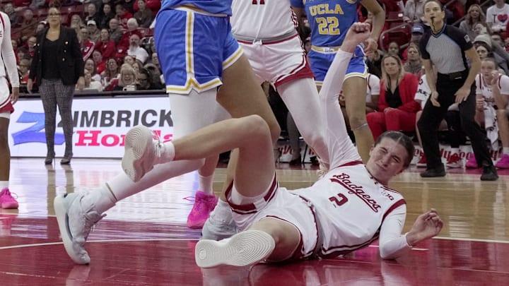 UCLA center Lauren Betts (51) scores as Wisconsin forward Alie Bisballe (2) stumbles during the first half of their game Wednesday, February 26, 2025 at the Kohl Center in Madison, Wisconsin.