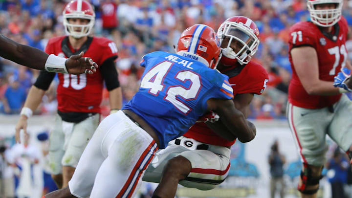 Oct 31, 2015; Jacksonville, FL, USA; Florida Gators defensive back Keanu Neal (42) tackles Georgia Bulldogs wide receiver Terry Godwin (5) during the second half at  EverBank Stadium. Florida Gators defeated the Georgia Bulldogs 27-3. Mandatory Credit: Kim Klement-Imagn Images