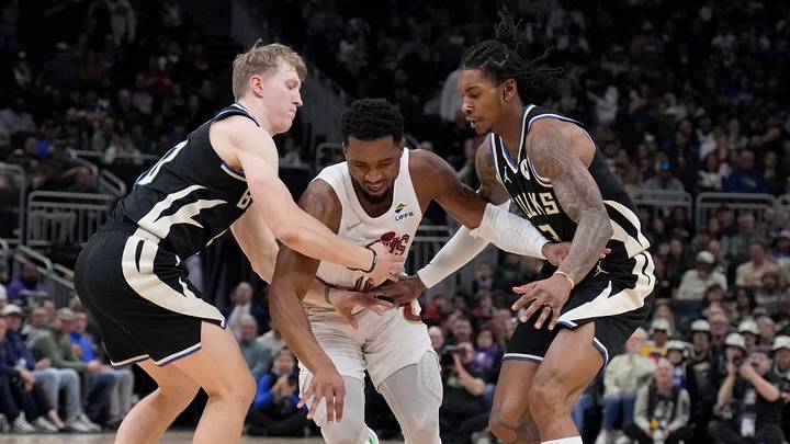 Mar 9, 2025; Milwaukee, Wisconsin, USA; Cleveland Cavaliers guard Donovan Mitchell (45) dribbles between Milwaukee Bucks guard AJ Green (20) and Milwaukee Bucks guard Kevin Porter Jr. (3) in the first half at Fiserv Forum. Mandatory Credit: Michael McLoone-Imagn Images