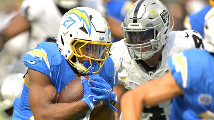 Sep 8, 2024; Inglewood, California, USA; Los Angeles Chargers running back J.K. Dobbins (27) breaks away from Las Vegas Raiders linebacker Divine Deablo (5) and runs for a touchdown in the second half at SoFi Stadium. Mandatory Credit: Jayne Kamin-Oncea-Imagn Images
