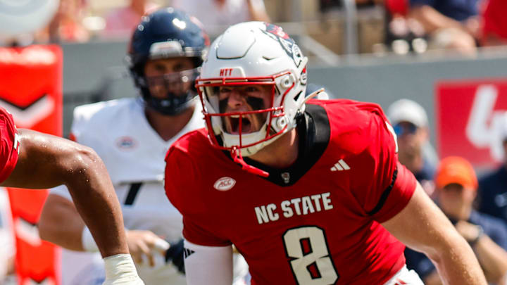 Sep 6, 2025; Raleigh, North Carolina, USA; North Carolina State Wolfpack offensive lineman Rico Jackson (64) celebrates a tackle against Virginia Cavaliers running back J'Mari Taylor (3) during the first half of the game at Carter-Finley Stadium. Mandatory Credit: Jaylynn Nash-Imagn Images Sep 6, 2025; Raleigh, North Carolina, USA; North Carolina State Wolfpack offensive lineman Rico Jackson (64) celebrates a tackle against Virginia Cavaliers running back J'Mari Taylor (3) during the first half of the game at Carter-Finley Stadium. Mandatory Credit: Jaylynn Nash-Imagn Images