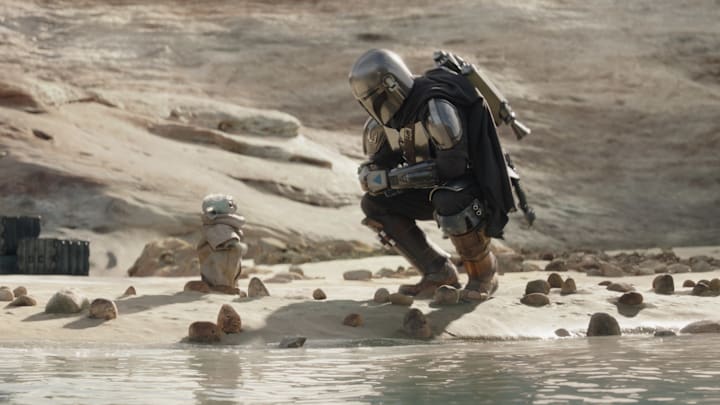 (L-R): Grogu and Din Djarin (Pedro Pascal) with stone crabs in Lucasfilm's THE MANDALORIAN, season three, exclusively on Disney+. ©2023 Lucasfilm Ltd. & TM. All Rights Reserved.