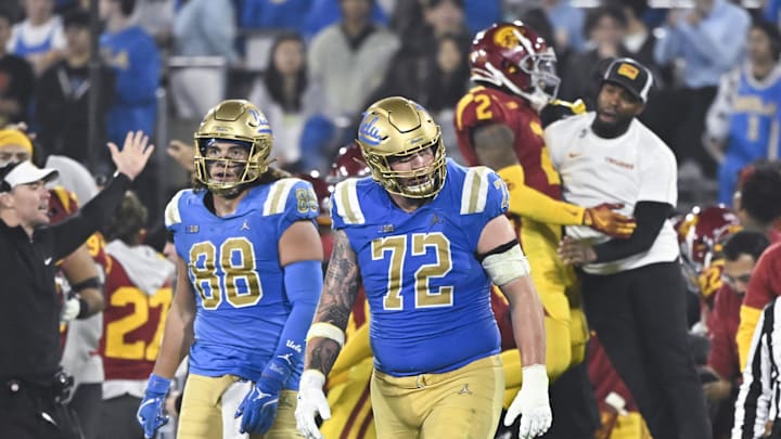Nov 23, 2024; Pasadena, California, USA; UCLA Bruins tight end Moliki Matavao (88) and UCLA Bruins offensive lineman Garrett DiGiorgio (72) walks off the field USC Trojans head coach Lincoln Riley (far left) and bench celebrates in the closing minute at Rose Bowl. Mandatory Credit: Robert Hanashiro-Imagn Images