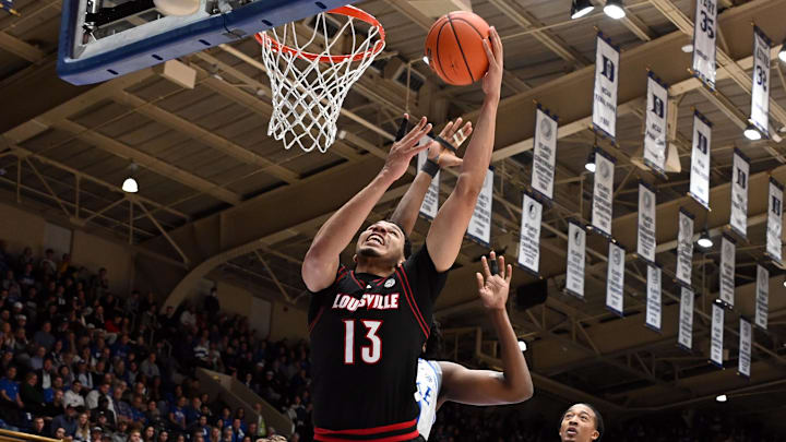 Jan 26, 2026; Durham, North Carolina, USA; Louisville Cardinals center Sananda Fru (13) lays the ball up in front of Duke Blue Devils center Patrick Ngongba II (21) during the first half at Cameron Indoor Stadium. Mandatory Credit: Rob Kinnan-Imagn Images